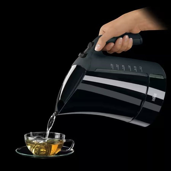 Taghareed Braun black electric kettle pouring hot water into a glass cup with tea. Features 3000W power and 1.7L capacity.