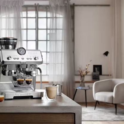 Espresso machine on a wooden table with a blurred living room background