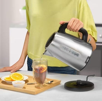 Braun PurShine stainless steel electric kettle pouring hot water into a glass with fruit slices. 1.7L capacity, 2200W.
