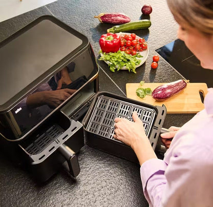 Braun TwinCook 5 Air Fryer TD5030IBK with dual 5L baskets, black finish, and digital display. Includes vegetables for cooking.
