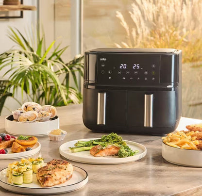 Braun TwinCook 3 dual basket air fryer in black, with digital display, cooking salmon and broccoli.
