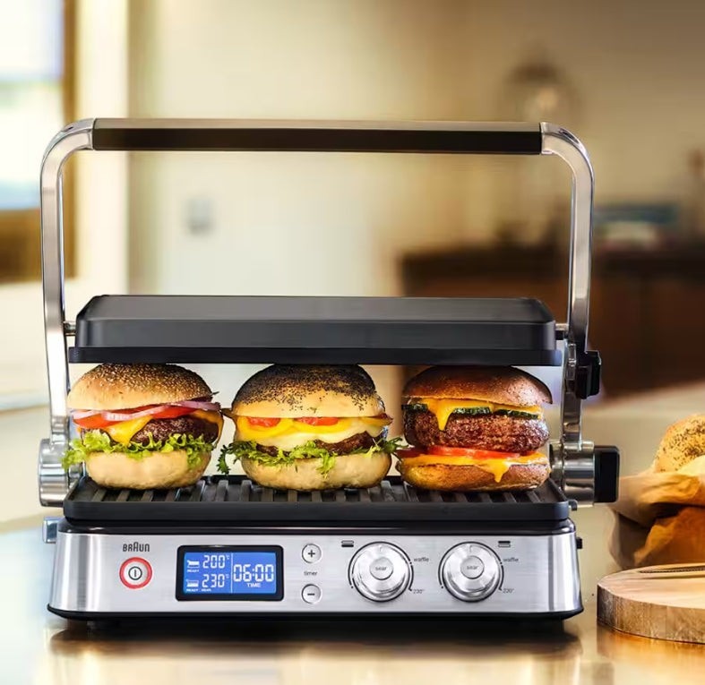 Taghareed Braun MultiGrill 9 CG9040 contact grill with three gourmet burgers cooking. Stainless steel.