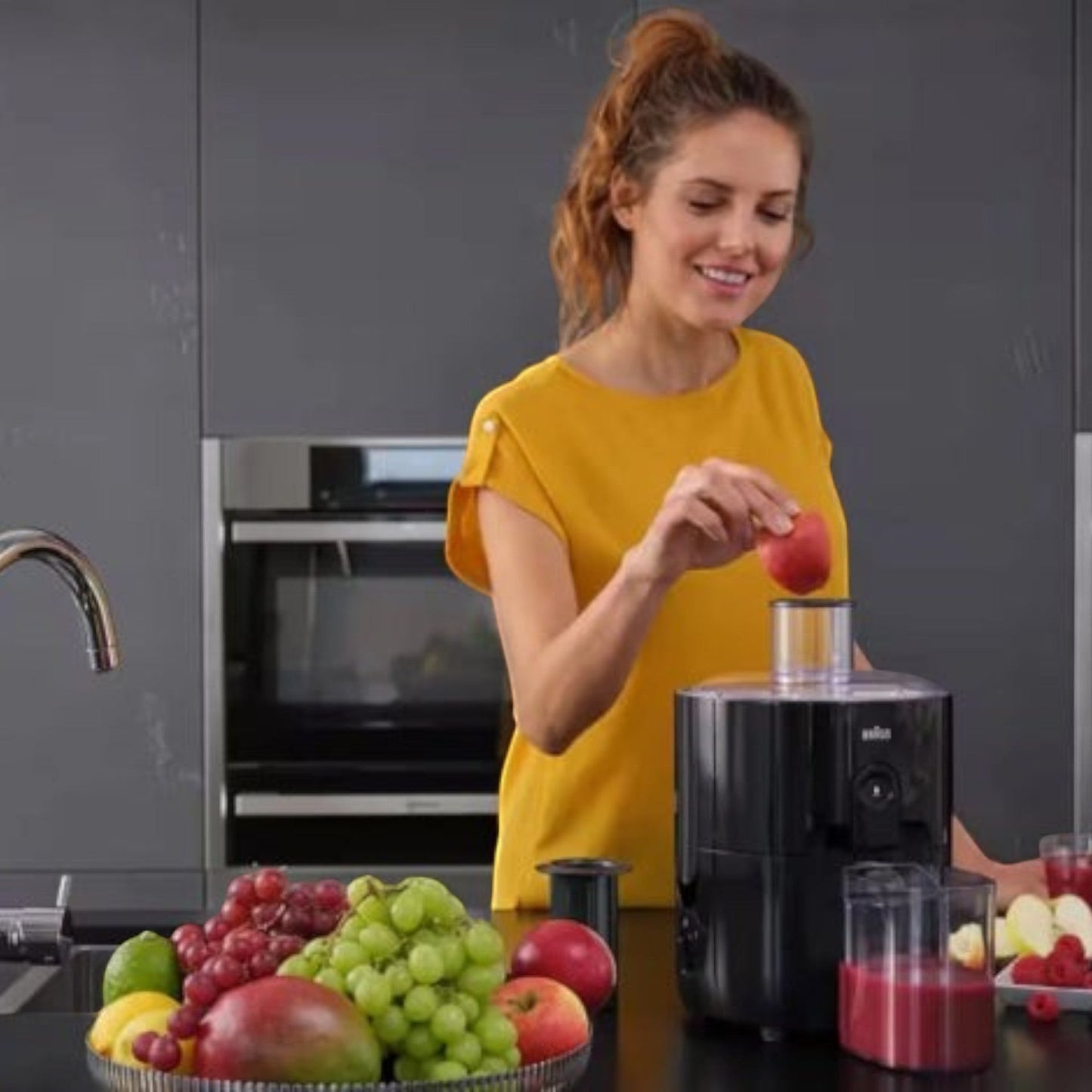Taghareed Braun PurEase Spin Juicer SJ3100BK, black, with 600W motor and 1.25L capacity, making fresh juice.