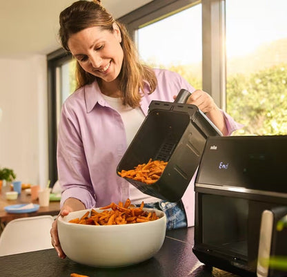 Taghareed woman pouring sweet potato fries from a Braun TwinCook 5 air fryer basket into a white bowl.