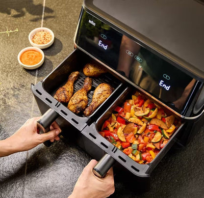 Taghareed Braun TwinCook 5 dual basket air fryer with chicken legs in one basket and chopped vegetables in the other.