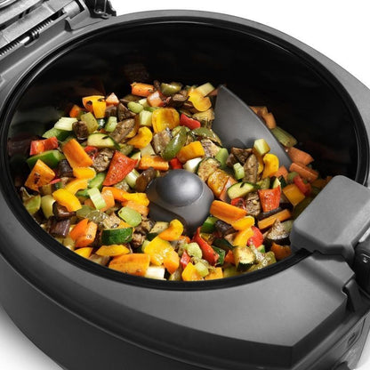 Taghareed De'Longhi MultiFry Extra Chef air fryer with mixed vegetables including peppers, zucchini, and carrots, featuring an automatic stirring paddle.