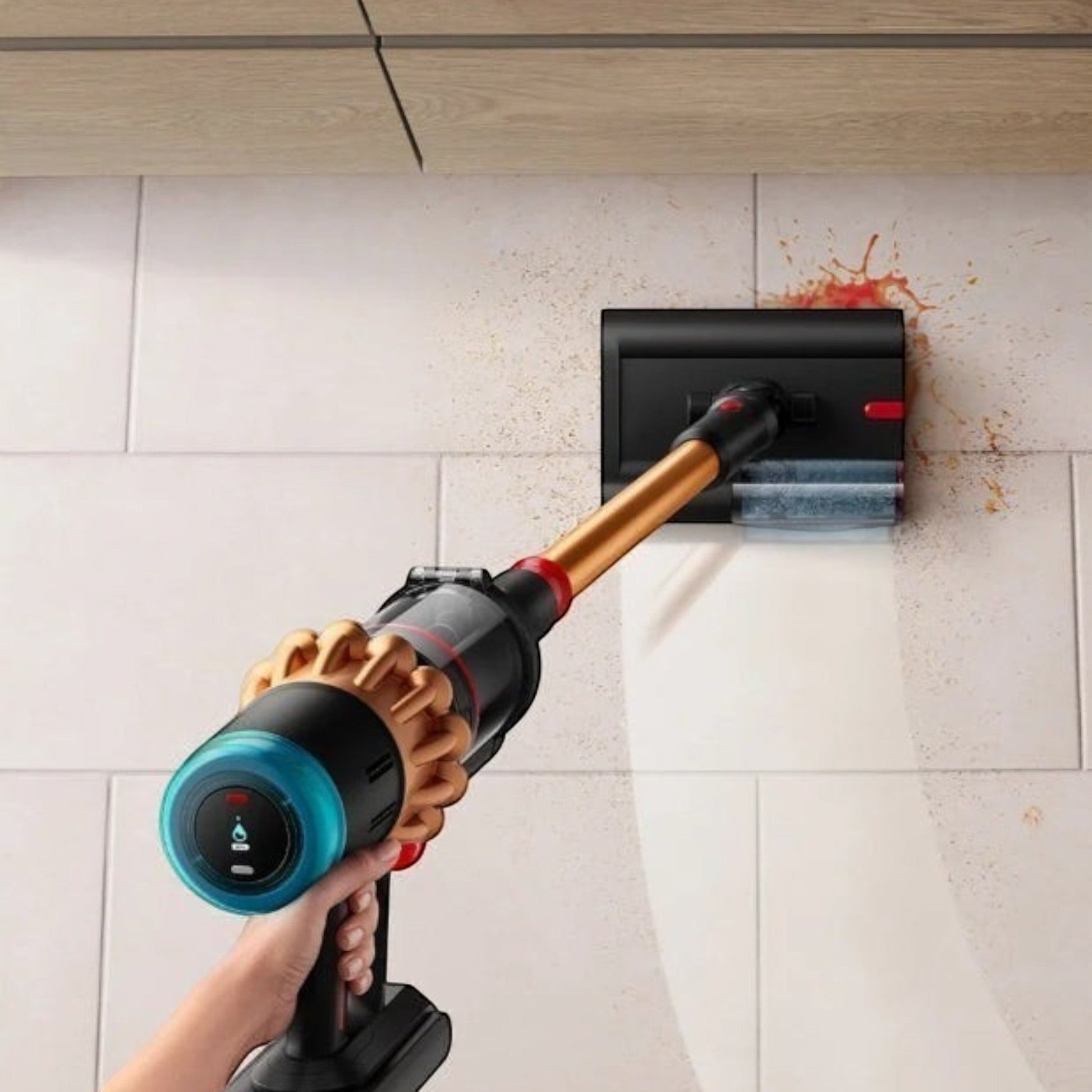 Taghareed Dyson V16 Piston Animal Submarine cordless vacuum in copper and black, cleaning spills on a tiled wall.
