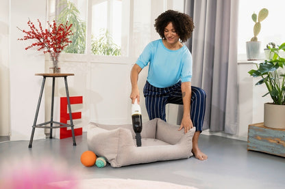 Taghareed Kärcher CVH 2 cordless handheld vacuum cleaner with HEPA filter, cleaning a pet bed.