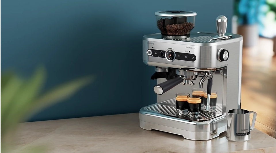 Taghareed Philips Barista Brew semi-automatic espresso machine with built-in grinder and stainless steel portafilter, brewing espresso.