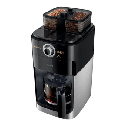 Taghareed Philips Grind & Brew coffee maker with dual bean hoppers, built-in grinder, and glass carafe. Black and silver.