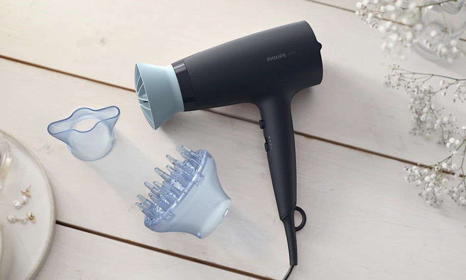 Taghareed Philips 3000 Series hair dryer in dark grey with light blue accents, includes diffuser and concentrator nozzle.