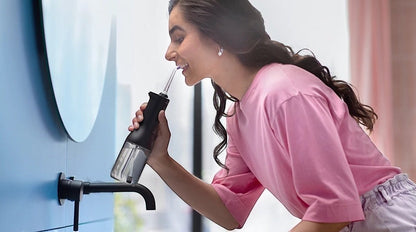 Taghareed Philips Sonicare Cordless Power Flosser 3000 HX3826/33 with 3 modes in black and clear, used by a woman.