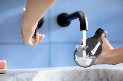 Taghareed Philips Sonicare Cordless Power Flosser 3000 HX3826/33 filling with water from a faucet. Black oral irrigator with 3 modes.