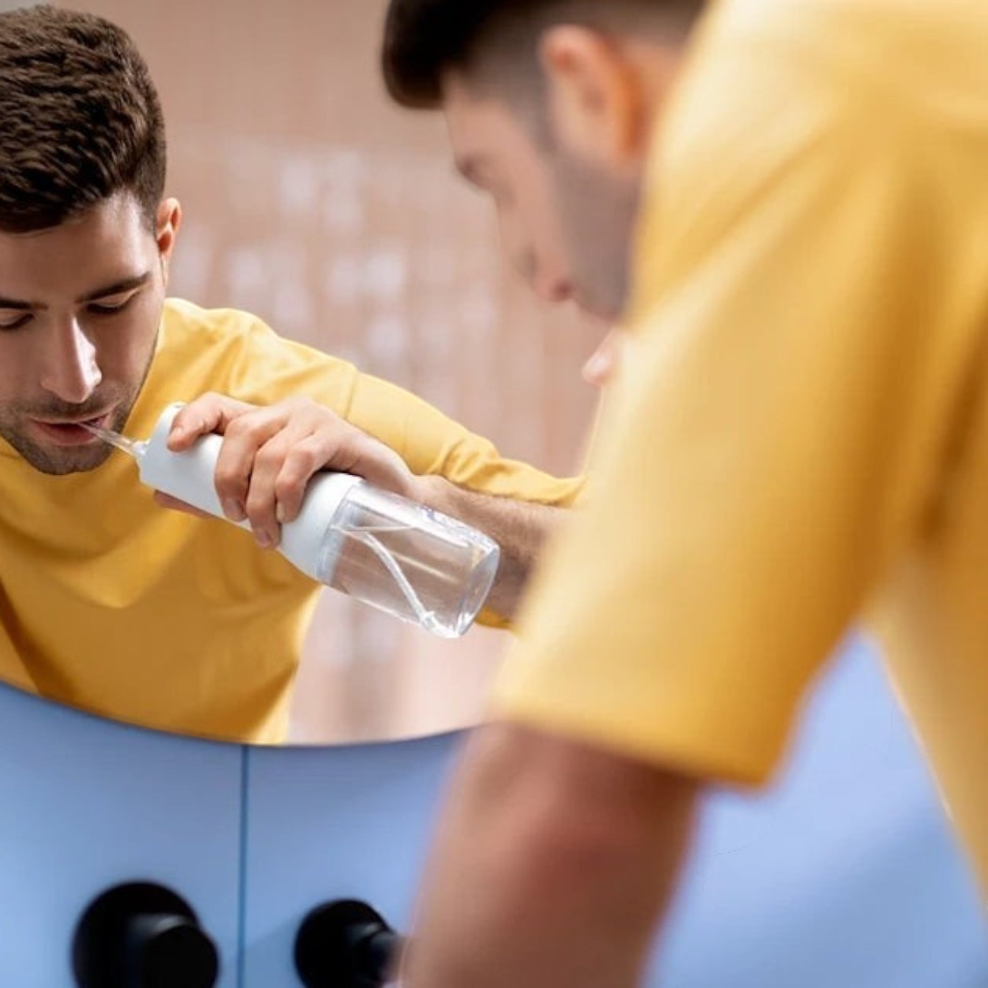 Taghareed Philips Sonicare Cordless Power Flosser 2000 white and clear plastic water flosser with a man using it.